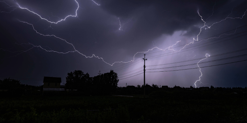 Lightning in the sky by utility poles