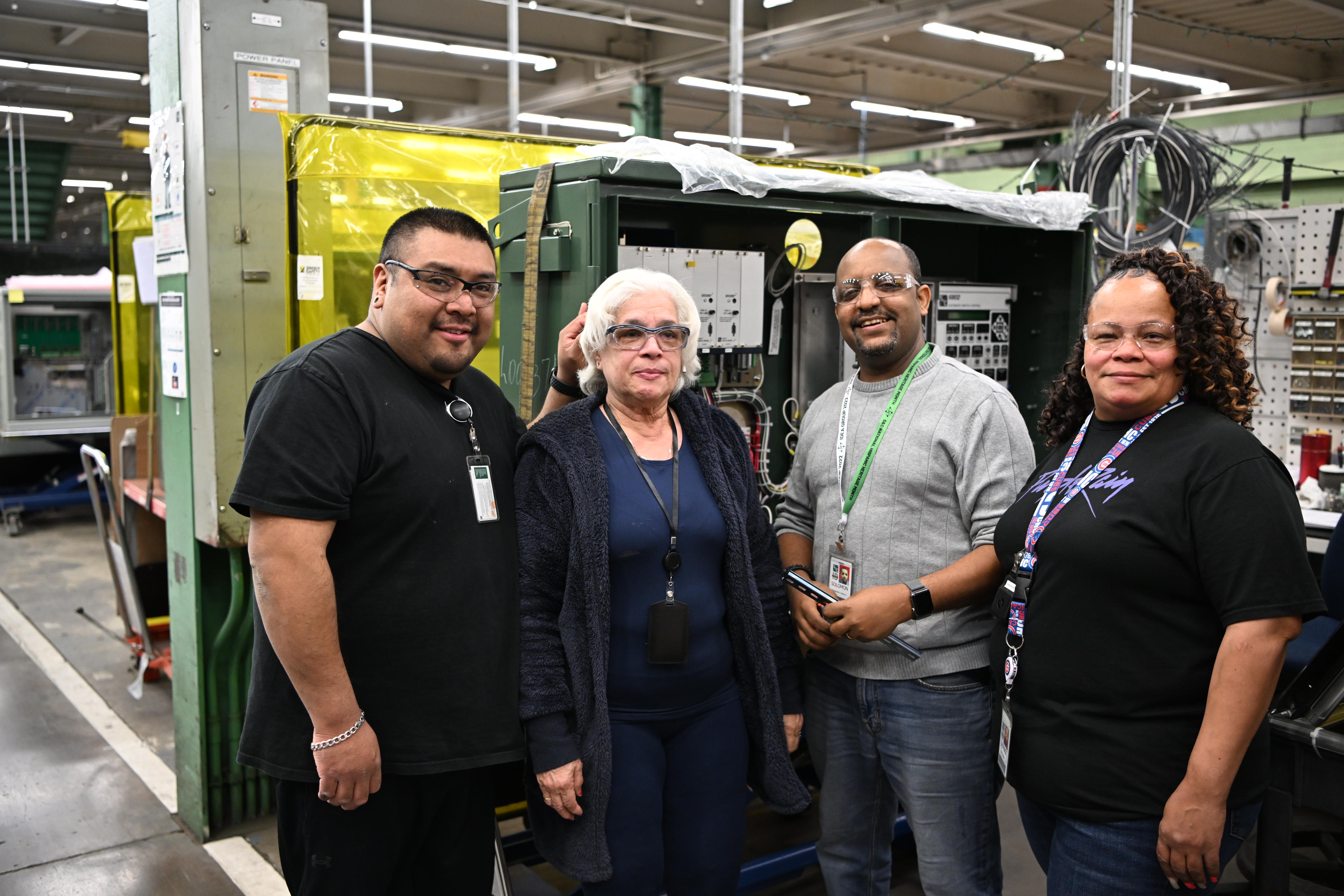 Four team members pose on the manufacturing floor Four team members pose on the manufacturing floor